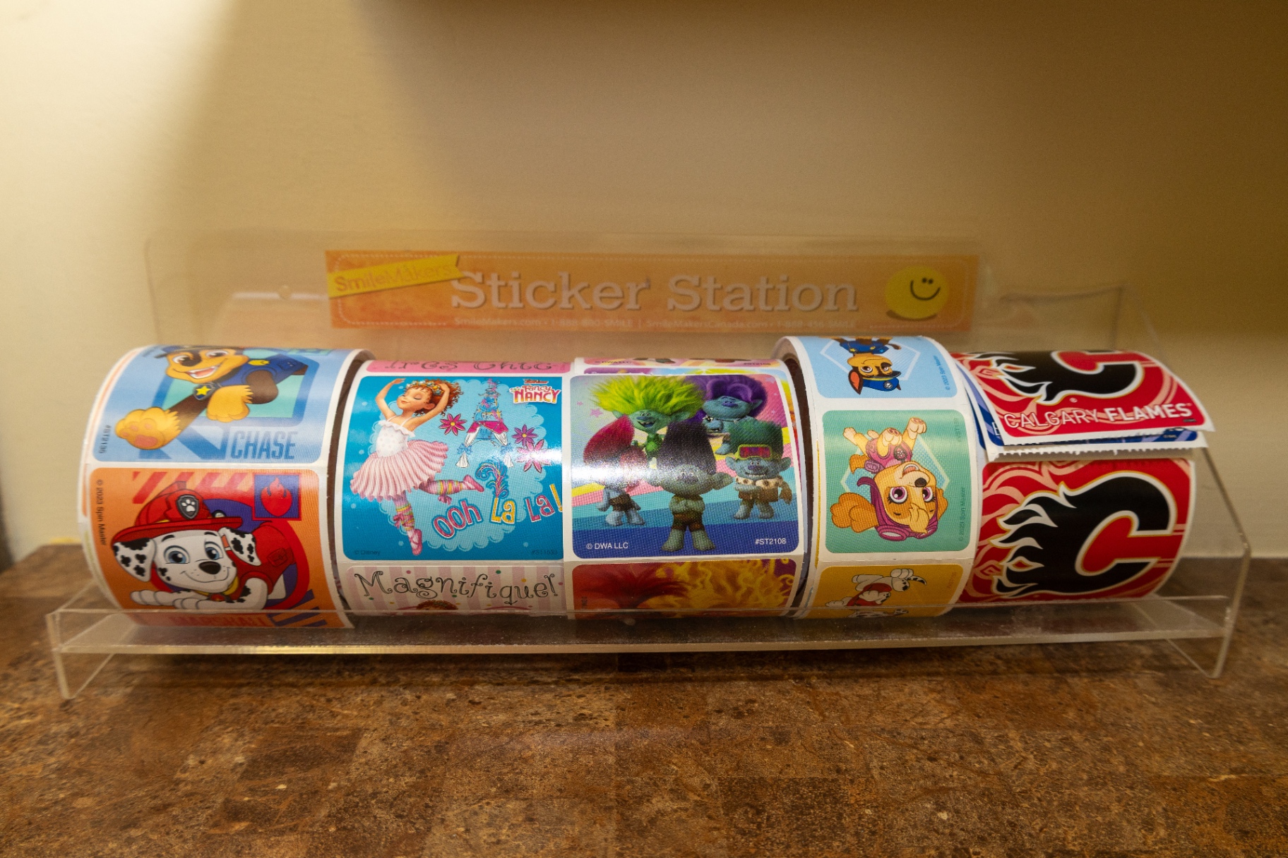 Clear sticker station holding several rolls of children's stickers