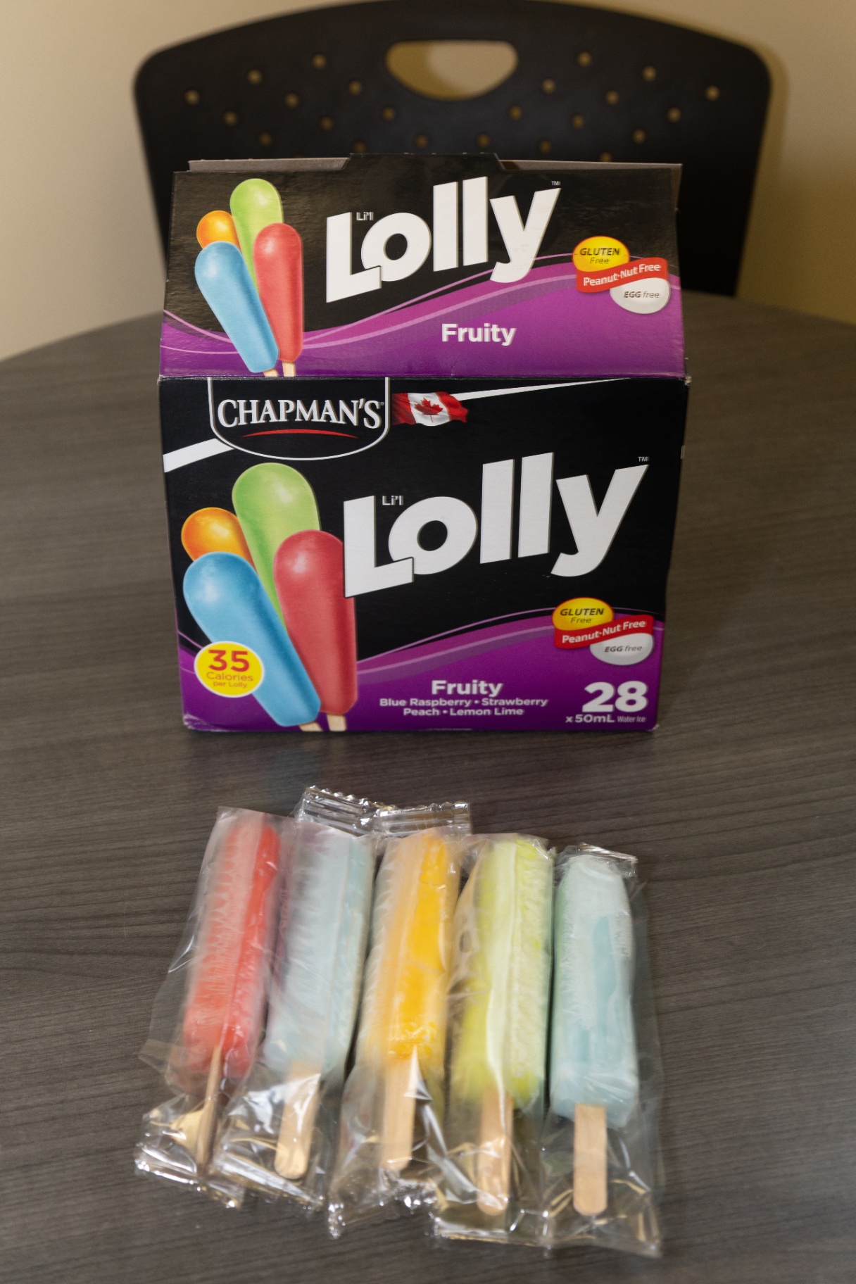 Box of fruity freezies with several individually wrapped lollies on a table